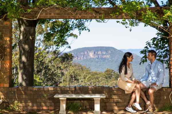 People sitting down on the stone wall at Everglades House & Garden
